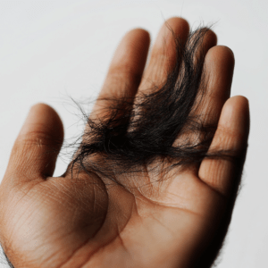 some_fallen_black_hairs_on_a_hand_zoomed_white_background